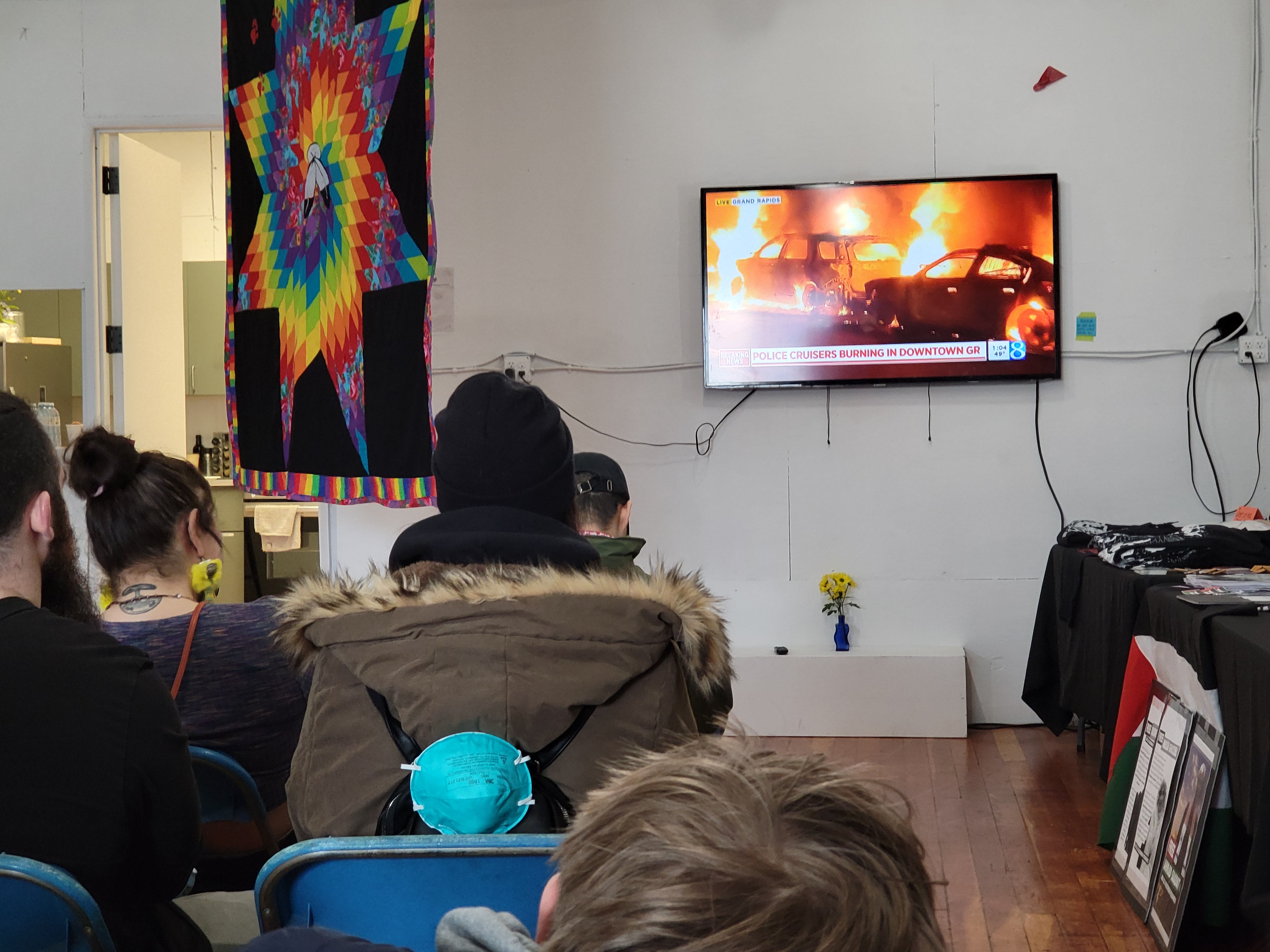Crowd watching burning cop cars video.