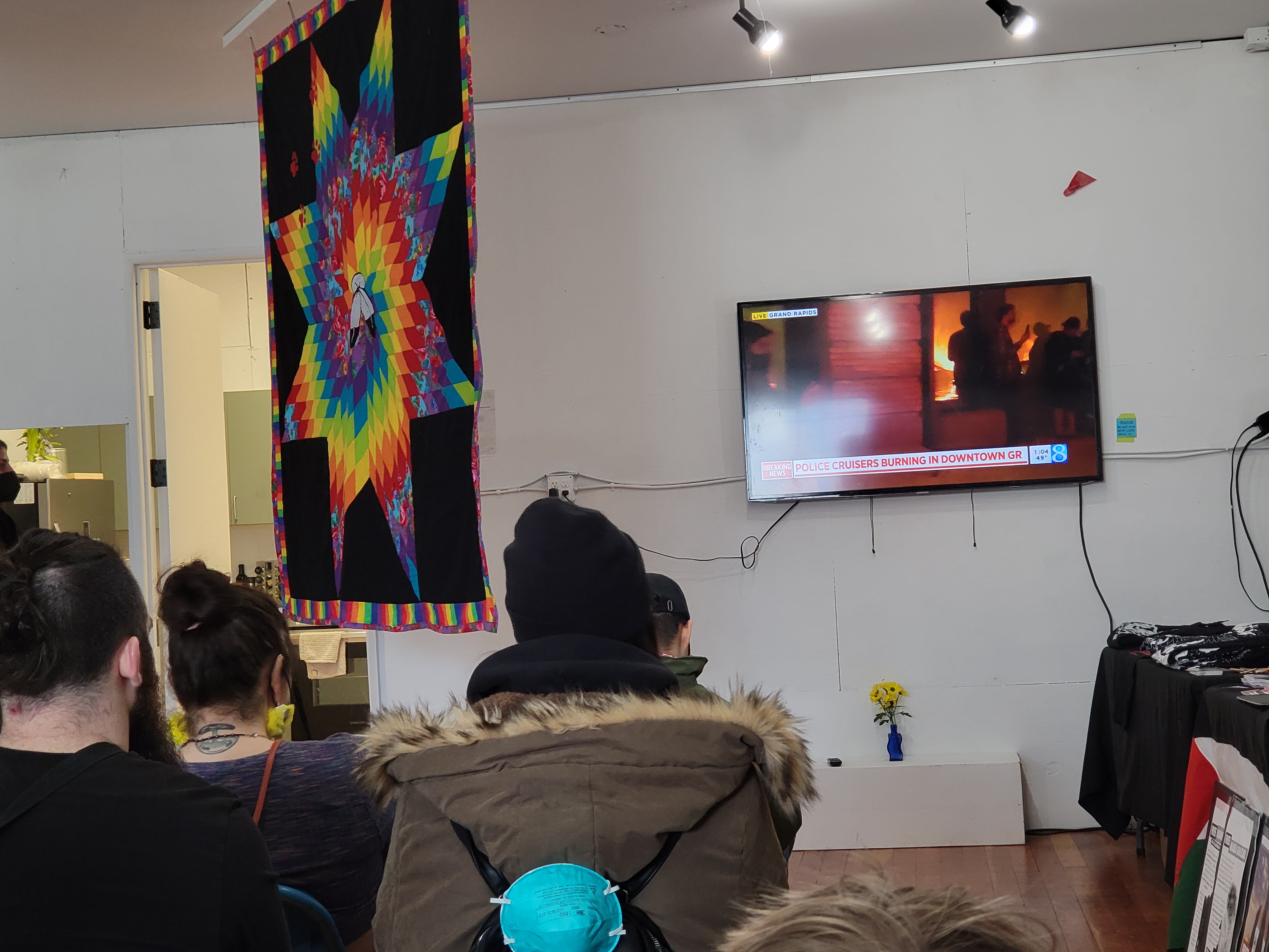 Crowd watching burning cop cars video.