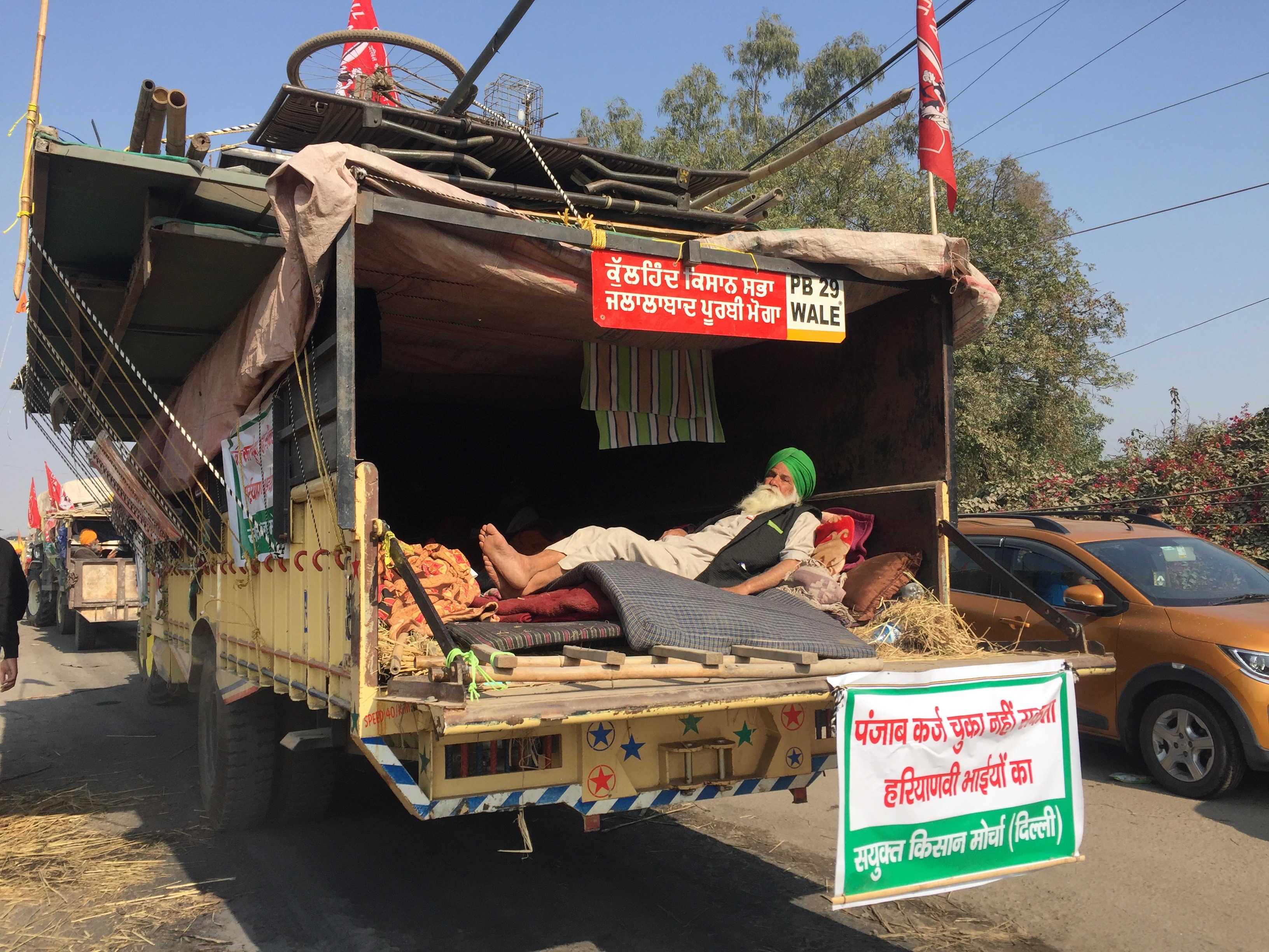 A farmer resting at the back of his truck as he heads home. Photo: Vandana K A farmer resting at the back of his truck as he heads home. Photo: Vandana K