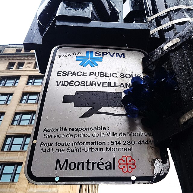 "Fuck the" graffiti on Montreal police surveillance sign.