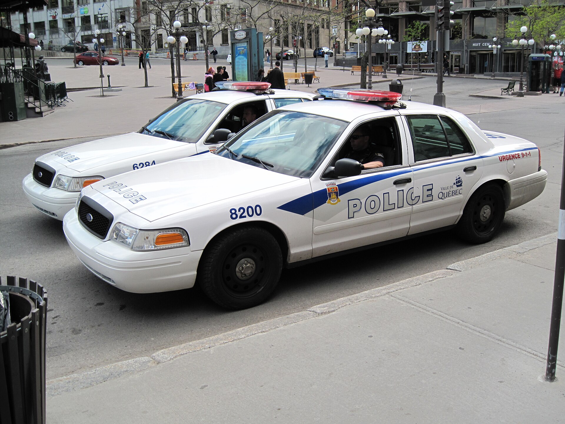 Two SPVQ police cars on street.