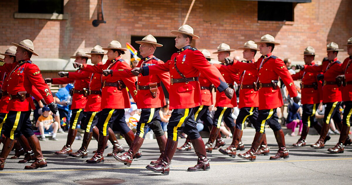 RCMP marching wearing red serge uniforms.