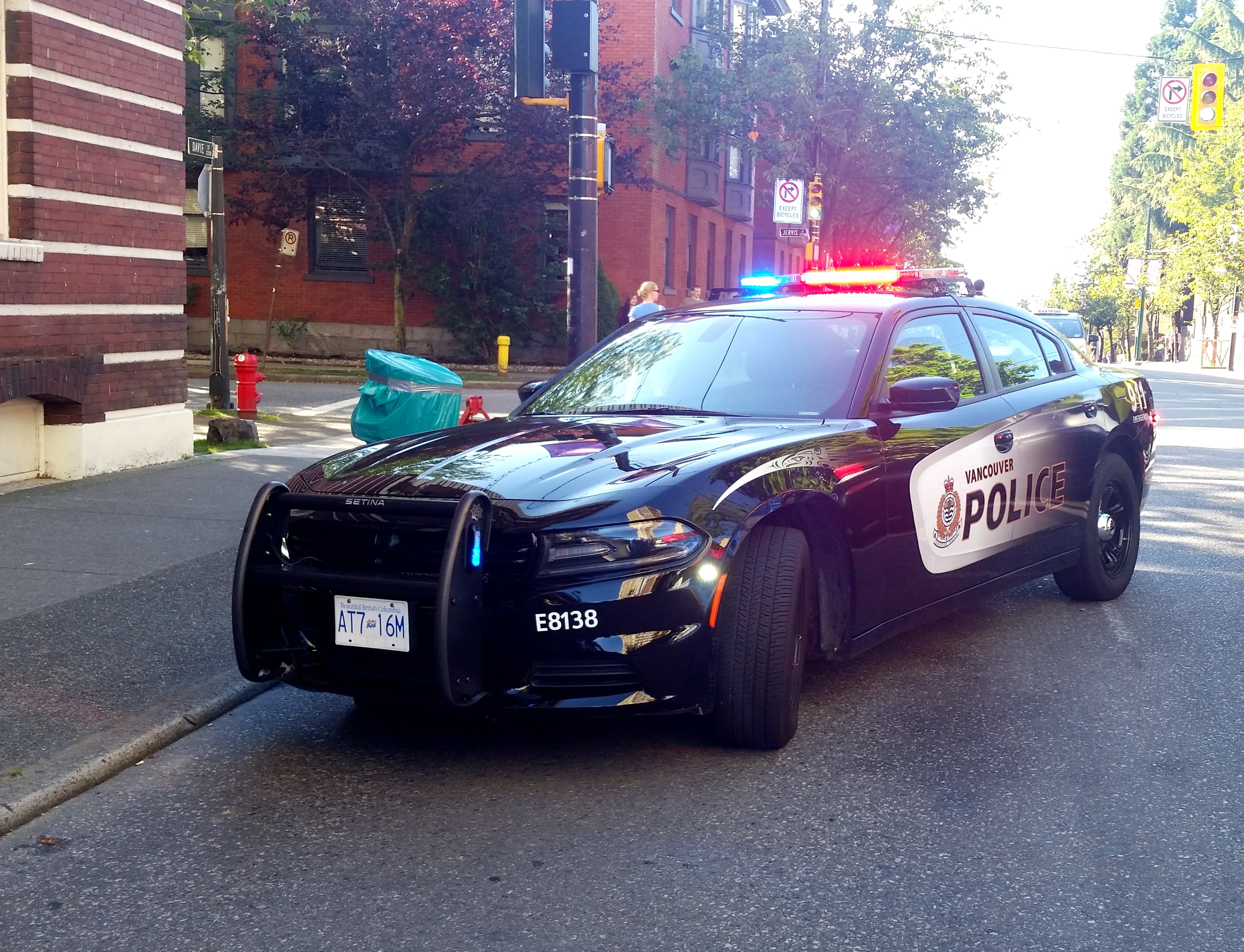 Vancouver police vehicle in roadway at a scene. Lights flashing.