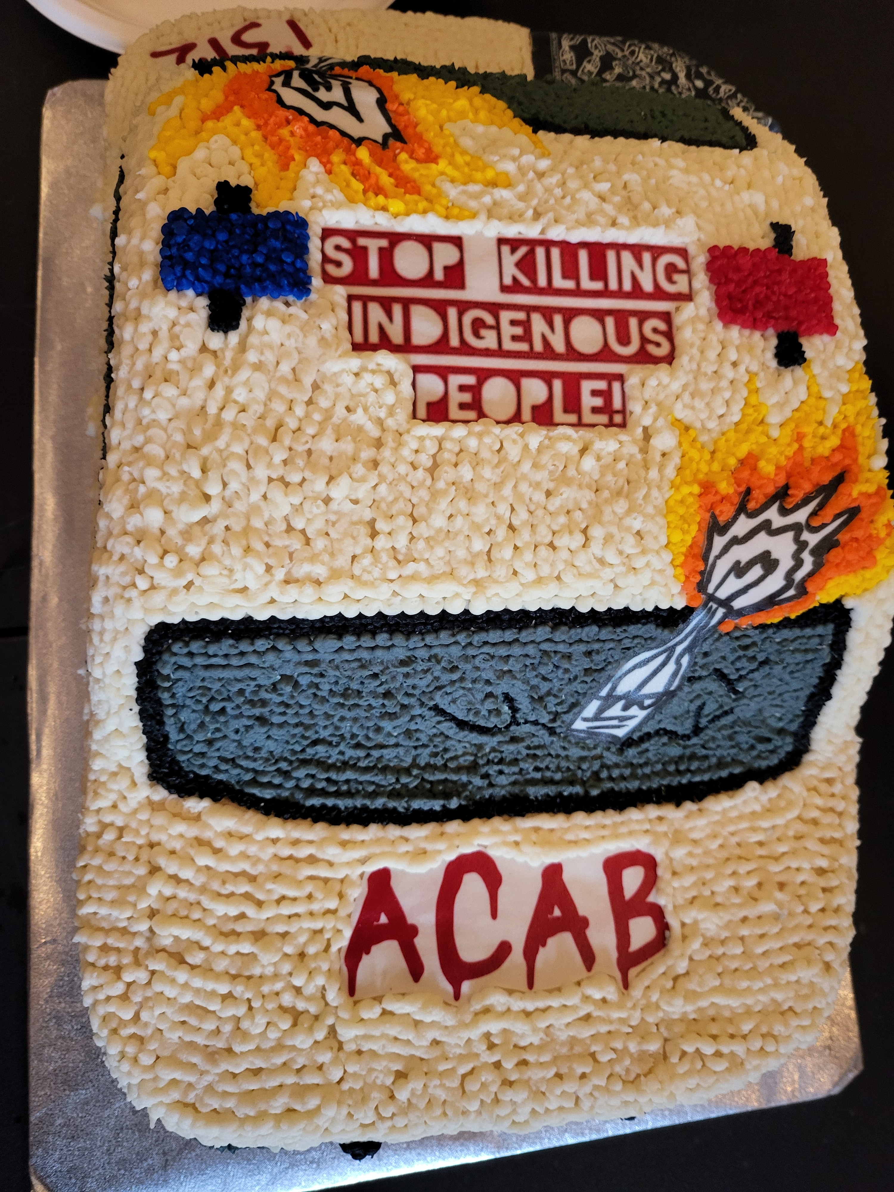 ACAB Cake. In shape of cop car. Says, "Stop killing Indigenous people" on top.