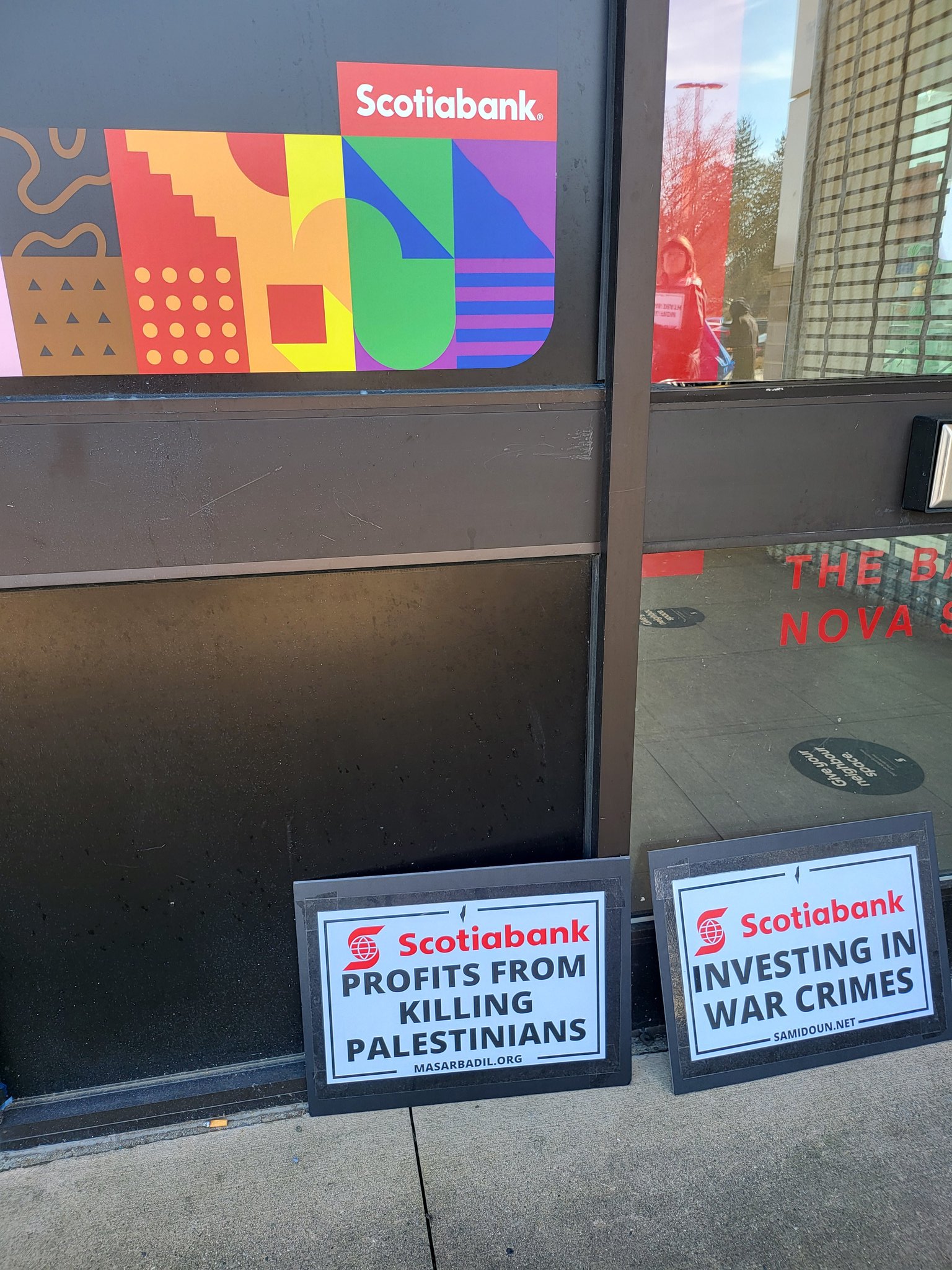 Scotiabank protest signs at door of Scotiabank.