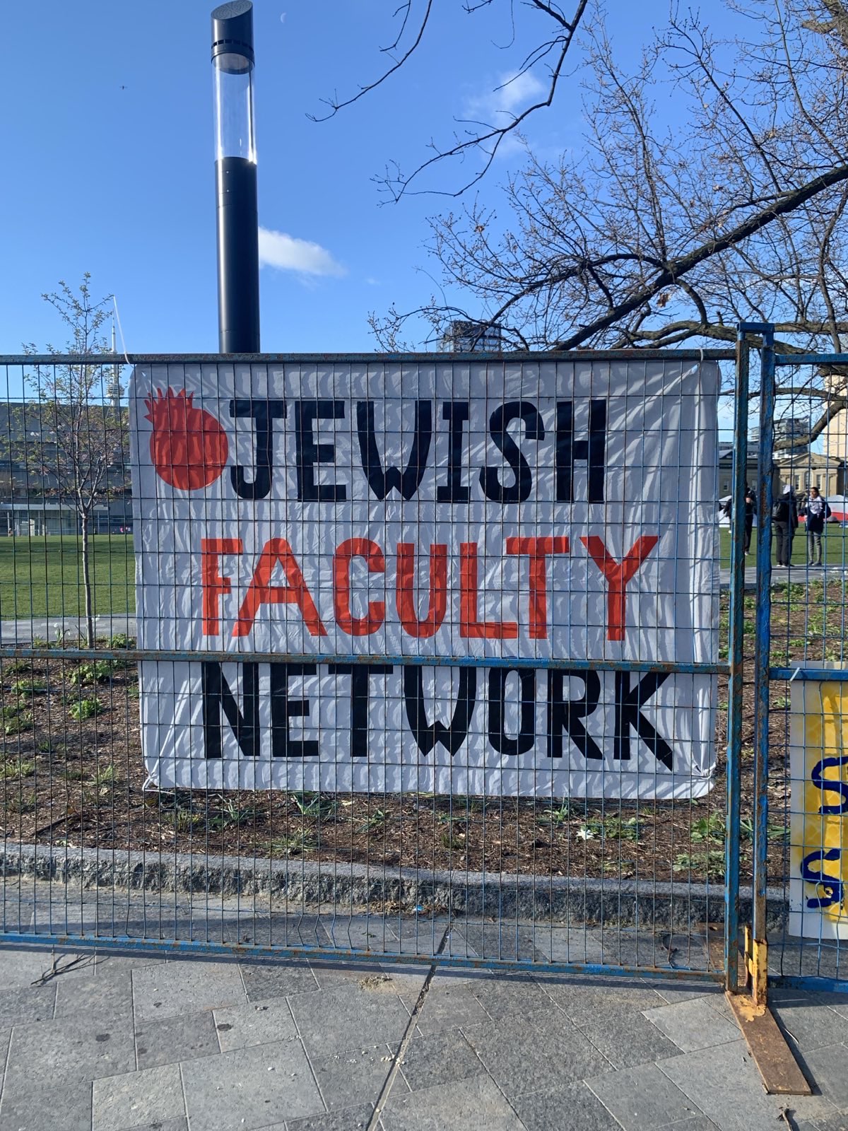 Photo of a banner reading "Jewish Faculty Network" on fencing outside the pro-Palestine encampment at the University of Toronto.