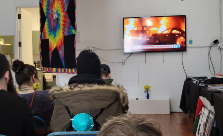 Crowd watching burning cop cars video.