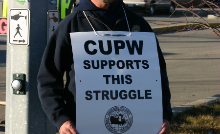 A postal worker showing solidarity with a community struggle. (Image: Wade Kelly via Flickr)