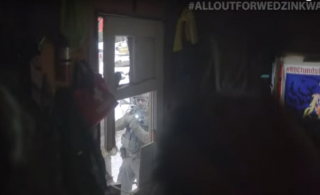 RCMP officer pointing gun at land defenders and media in tiny house on Wet'suwet'en Yinta (territory), November 19, 2021.