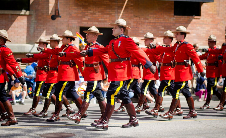 RCMP marching wearing red serge uniforms.